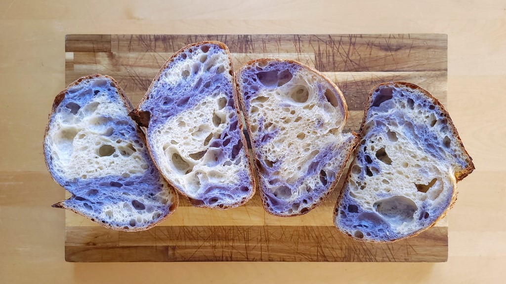 Here’s a recipe for when you’re feeling playful or want a visually striking slice of bread. It involves mixing two doughs, one of which is hydrated with butterfly pea flower tea to create a bright, blue-violet crumb. Folding together the white and violet doughs is fun, and cutting into the final loaf to see how they ended up swirling together even more so.